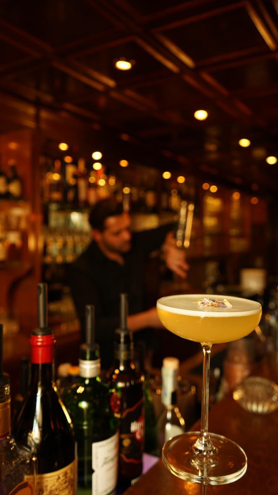 Cocktail auf der Bar mit Barkeeper im Hintergrund